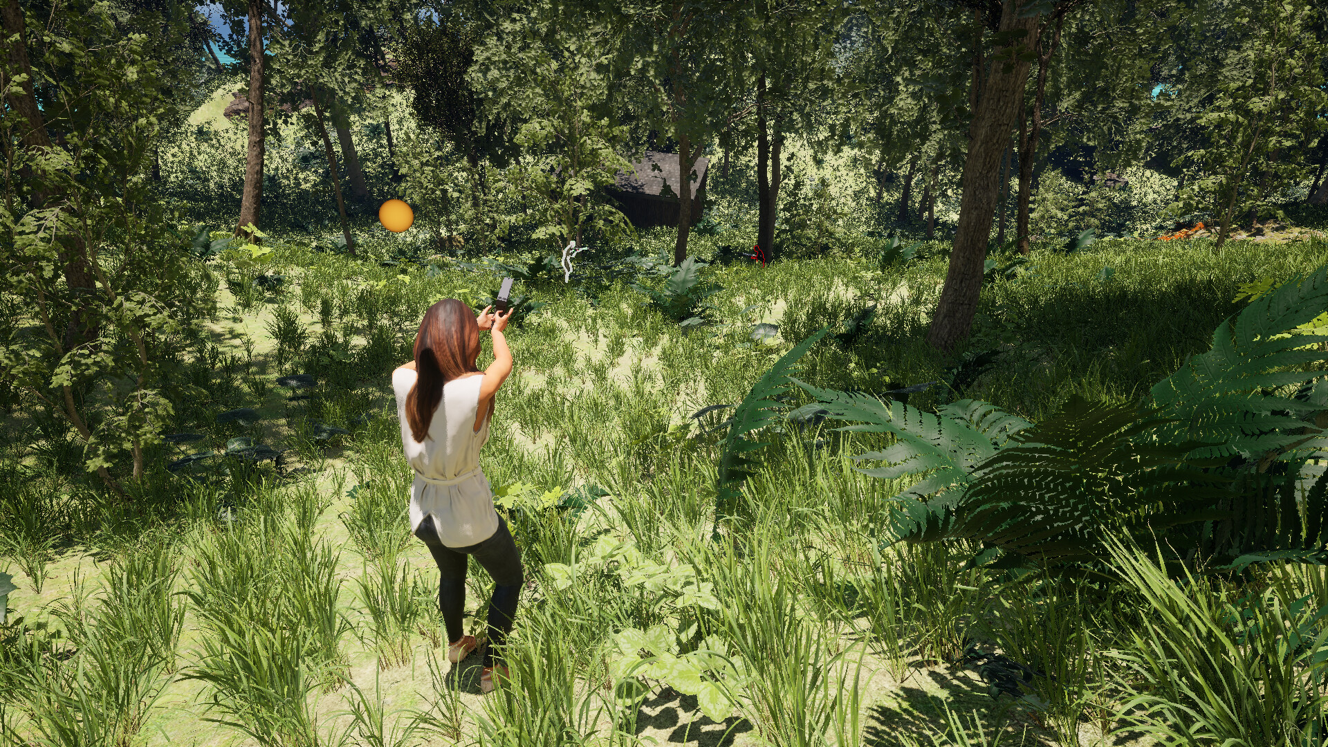 The image shows a woman standing in a dense, sunlit forest clearing, surrounded by tall grass and various green plants and ferns. She is facing away from the viewer and aiming a handgun at two distant, ghostlike figures, one white and one red, who are partially obscured by foliage. Tall trees with leafy branches create a canopy overhead, and a small, dark wooden cabin is partially visible in the background amidst the greenery.