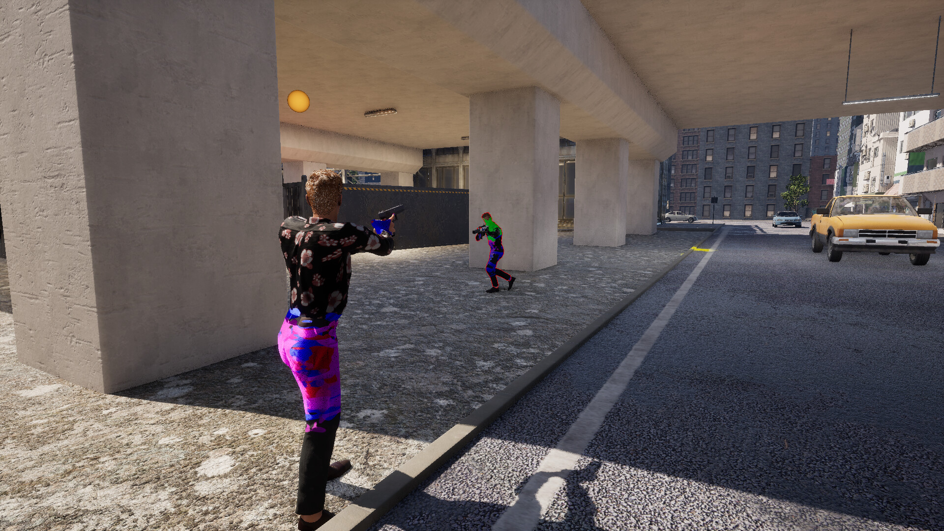 The image shows two figures under a concrete overpass in an urban setting. The person in the foreground, seen from behind, wears brightly colored pants with a camouflage pattern in purple, pink, and red, along with a black shirt with a floral design, and is holding a handgun aimed at the other figure. The second figure, farther away near a large concrete pillar, is dressed in a similarly colorful pattern and appears to be holding a camera or similar device. To the right, a street with a few parked cars, including a yellow car closest to the foreground, extends into the distance with multi-story buildings lining the street.