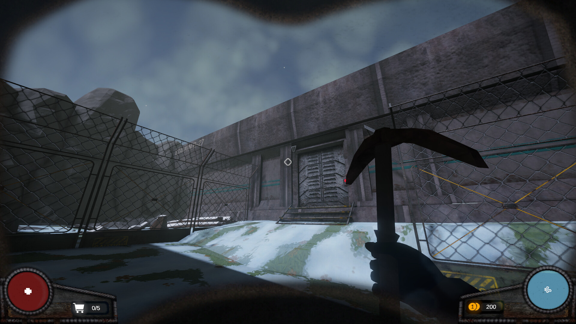 The image shows a first-person perspective from a video game, where the player is holding a pickaxe in their right hand. The scene depicts an outdoor area with a chain-link fence surrounding a concrete building with a heavy, industrial metal door in the center. The ground is covered with patches of snow and grass, and the sky is cloudy with a grayish-blue hue. In the lower corners of the screen, game interface elements display a red health indicator on the left and a blue circular meter on the right, along with icons showing the player’s available items and currency.