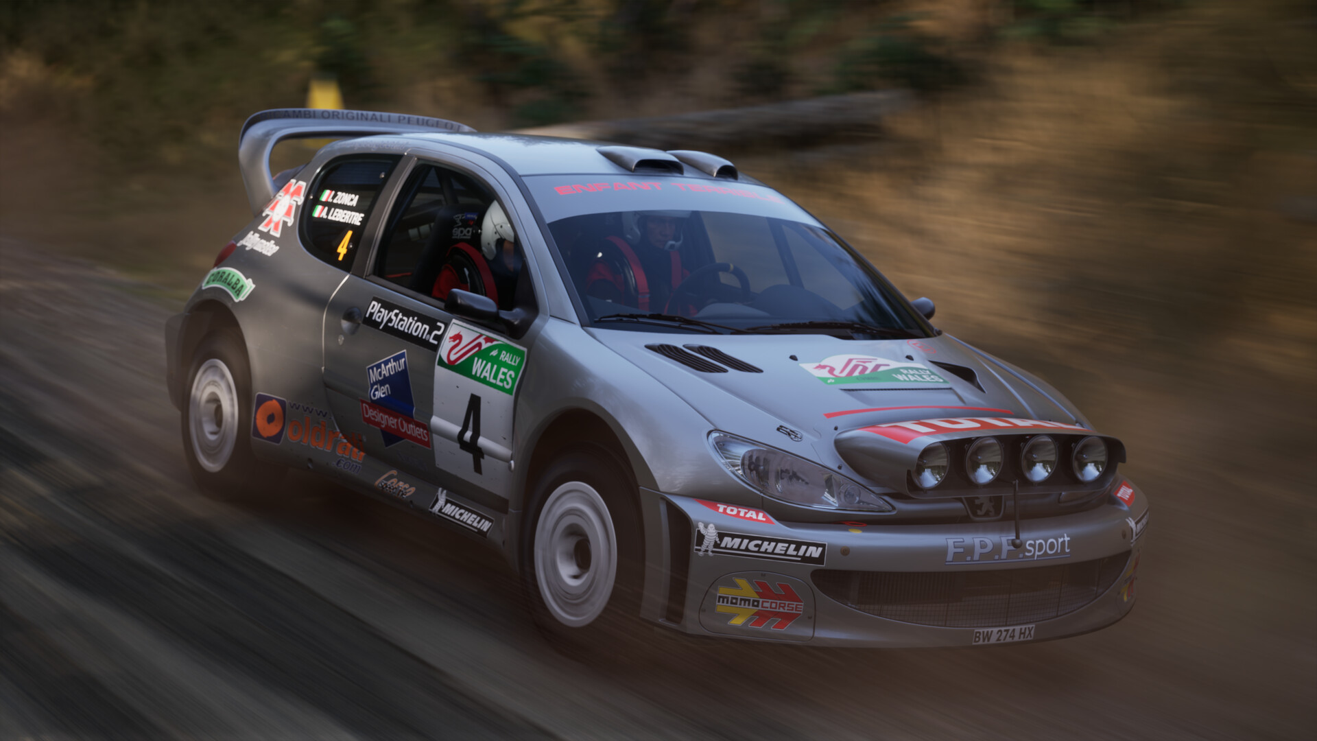 A silver rally car carrying the number 4 on a gravel stage in Assetto Corsa Rally.