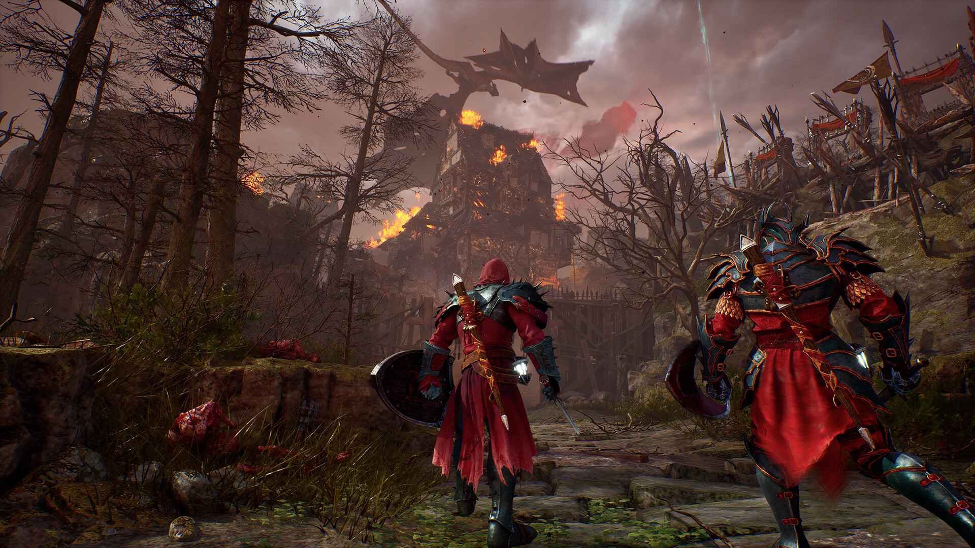 Two red-armoured characters walk toward a burning building with a winged creature silhouetted overhead, banners and spears lining a hillside path.