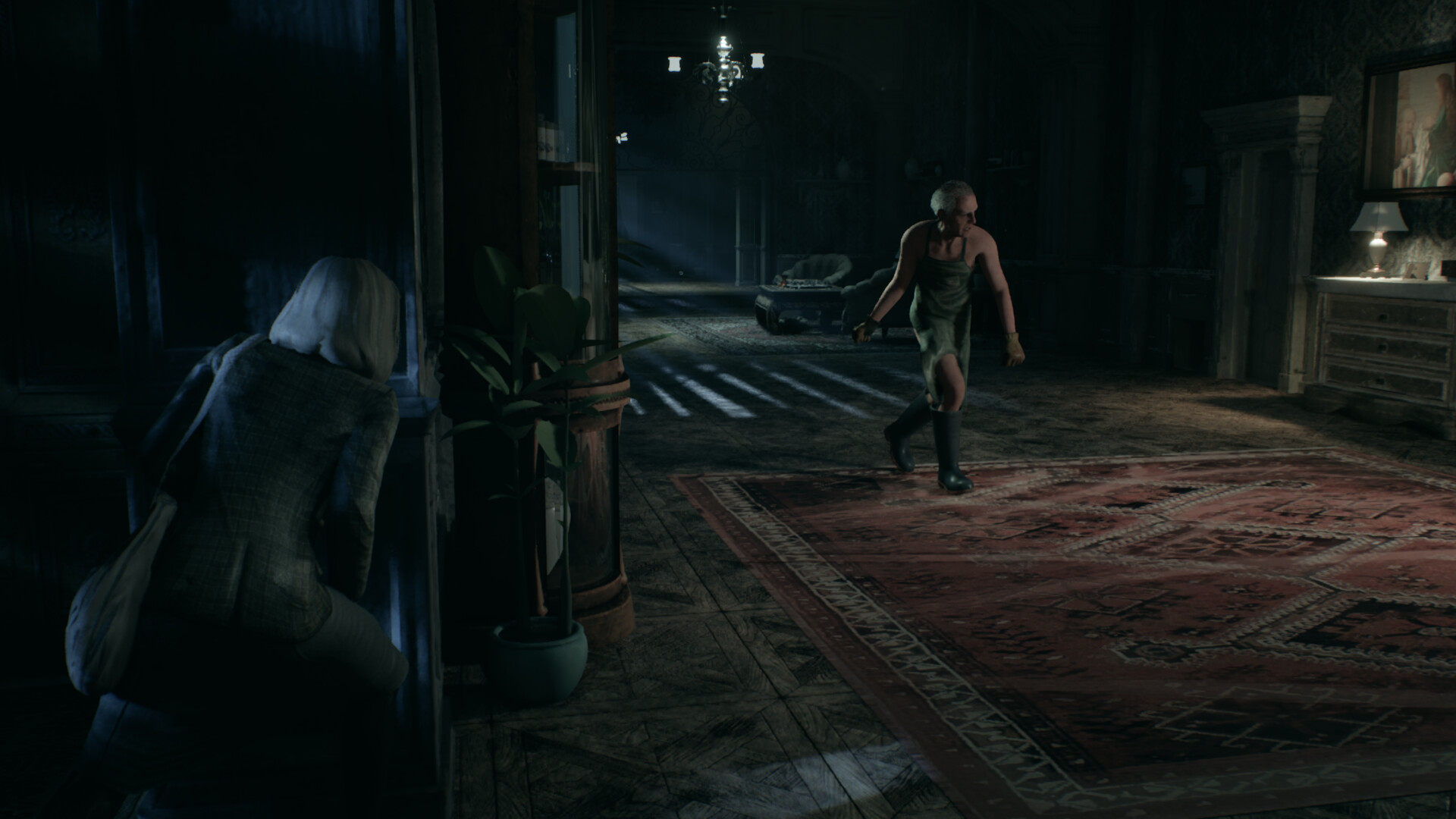 Rosemary Reed crouches behind a doorframe as the elderly Richard Felton, in an apron and rubber boots, prowls across a rug-covered hall